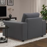 In the living space, a gray VIMLE sofa armchair is placed against a wall, with a round black side table beside it holding a white mug and remote.