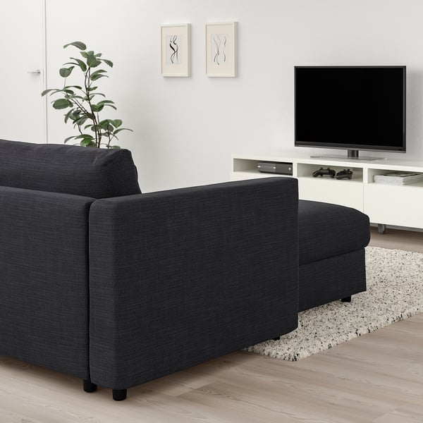 Modern living room with grey VIMLE sectional sofa, tv, plant, rug, abstract art, natural light.