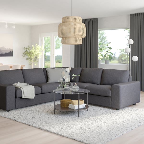 Modern living room with grey VIMLE sectional sofa, wooden coffee table, white rug, large window, and unique pendant light.