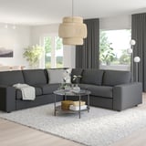 Modern living room with VIMLE sectional, glass table, rug, and lamp. Large windows with curtains.