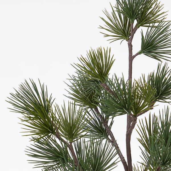 A close-up of lifelike pine branches, showcasing fine details of green needles and textured bark, creating a realistic and natural appearance.