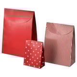 Three red paper bags. One is plain, another has white stars, and the third red and white stripes.