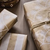 Elegant wrapped gifts in quality paper with floral patterns, tied with twine.