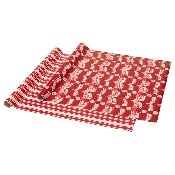 Two rolls of festive red gift wrapping paper, one striped, the other with white holly designs.