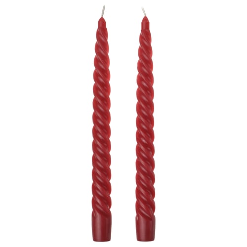 Two red twisted candles. Simple, festive, spiral design. Made from cotton and wax. Perfect for holiday decor.
