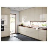 Modern, glossy beige kitchen cabinets with sleek, integrated handles and minimalist design.