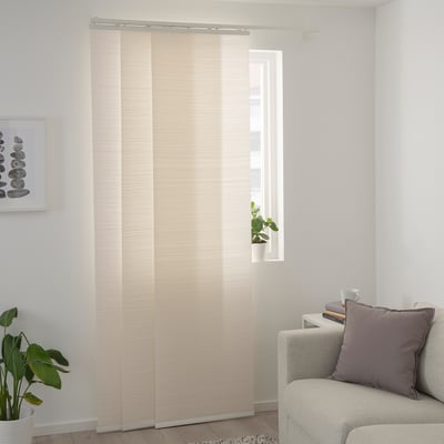 Modernes Wohnzimmer mit durchsichtigen weißen Vorhängen, grauem Sofa, lila Kissen, Couchtisch und Pflanze.