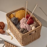 Korb mit buntem Garn und Stricknadeln, ideal zum Basteln und Aufbewahren.