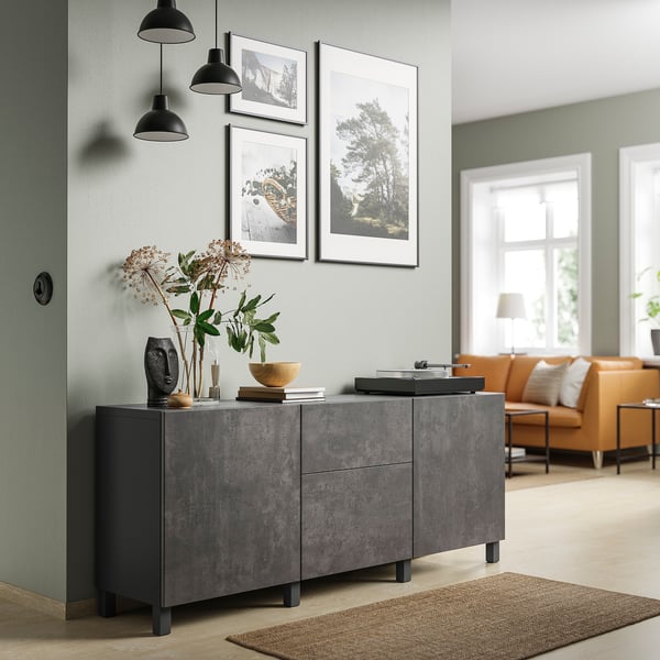 Modernes Wohnzimmer mit grauem BESTÅ-Stauraum mit schwarzen Pendelleuchten und orangefarbener Sitzecke.
