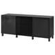 Schwarzes BESTÅ Sideboard: drei Abschnitte, glänzende Glastüren, Beine aus dunklem Holz.