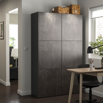 Zeigt einen dunkelgrauen IKEA BESTÅ-Schrank mit sechs quadratischen Türen mit mattem, betonähnlichem Finish, verstellbaren Scharnieren und einer rechteckigen Form.