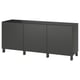 Ein schwarzes Ikea BESTÅ Sideboard mit drei Türen und spitz zulaufenden Beinen.