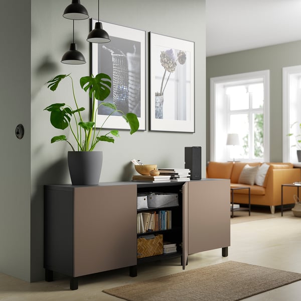 Modernes Wohnzimmer mit BESTÅ Sideboard mit Pflanzen, Büchern und Dekoration, mit Soft-Close-Türen und verstellbaren Regalen.
