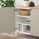 Offener Schrank mit einem verstellbaren Regal mit Holzschale und gelagerten Gegenständen, Pflanzen und Dekor darauf.