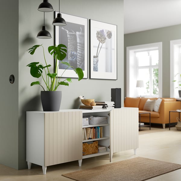 Modernes Wohnzimmer mit BESTÅ Sideboard, Dekor, Büchern und Pflanzen.