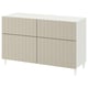Weißes BESTÅ Sideboard mit vertikalen Paneelen, rechteckiger Form, vier Türen und leicht spitz zulaufenden Beinen.