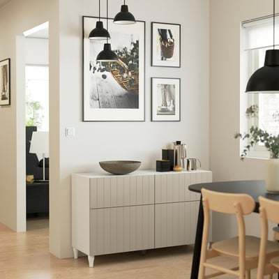 Modernes Wohnzimmer mit BESTÅ Sideboard, Lampen und Stühlen.