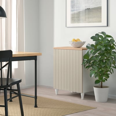 Modernes Wohnzimmer mit BESTÅ-Stauraum, Tisch, Pflanze, Teppich und Zitronenschale.