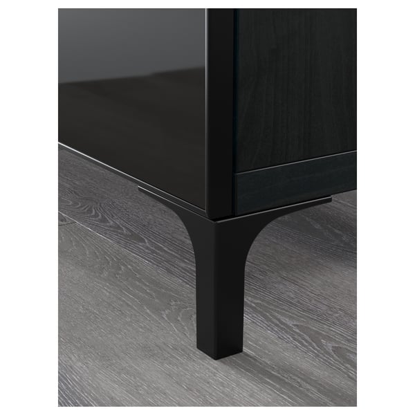 Modernes schwarzes TV-Ständer-Detail: schlanke Glasplatte, robuste Metallbeine, hochwertige Verarbeitung.