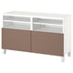Eine IKEA BESTÅ TV-Bank in Weiß mit braunen Türen. Er hat ein offenes Regal und zwei Schranktüren mit schlichtem Design und quadratischen Beinen.
