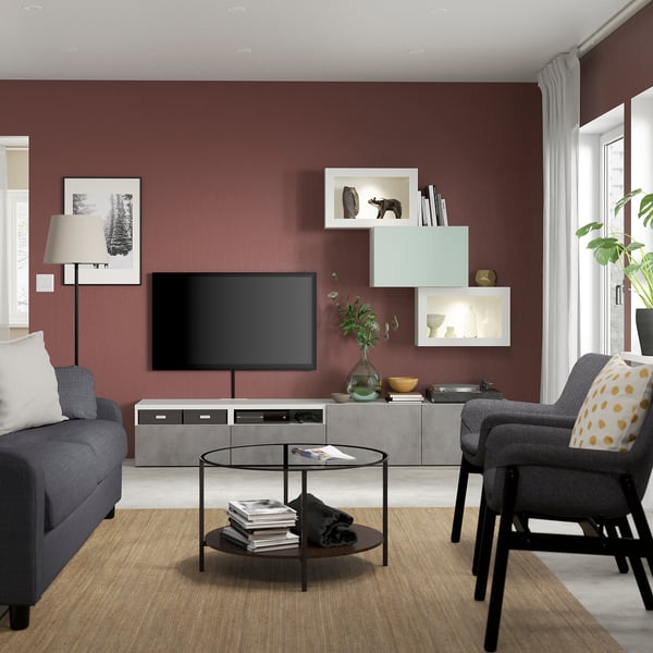 Modernes Wohnzimmer mit kastanienbraunen Wänden, grauen Möbeln und einem großen Flachbildfernseher auf einer grauen BESTÅ-TV-Kombination.