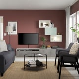 Modernes Wohnzimmer mit kastanienbraunen Wänden, grauen Möbeln und einem großen Flachbildfernseher auf einer grauen BESTÅ-TV-Kombination.
