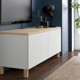BESTÅ Kabine mit Holzplatte, Dekor, TV, Teppich, modernes Ambiente.