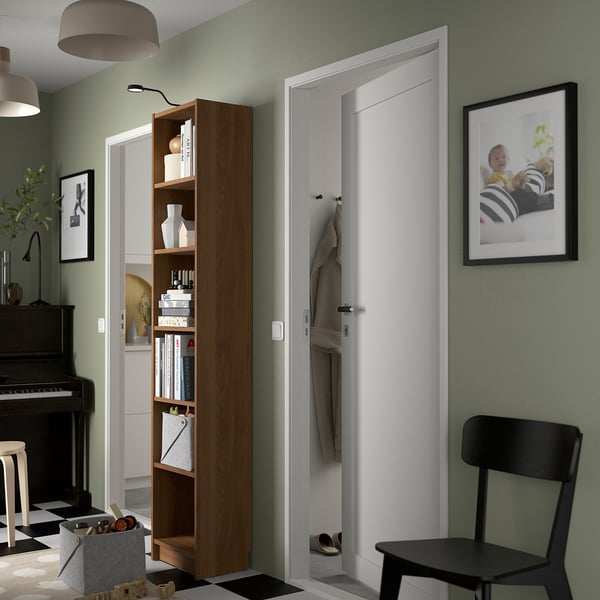 Salbeigrünes Zimmer, BILLY Bücherregal neben der Tür, schwarzer Stuhl, Klavier, gerahmtes Babyfoto.