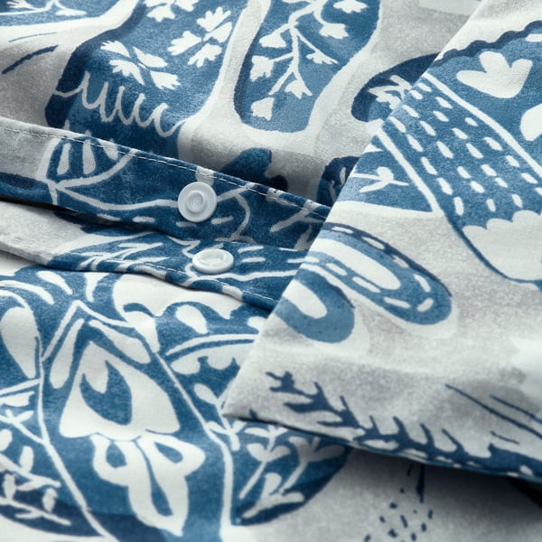 Blau-weißes Bettdeckenset mit Vogelmuster und abgebildetem Rabatt-Druckknopfverschluss.