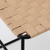 Sitz aus geflochtener Jute auf schwarzem Metallhocker, der von robuster Handwerkskunst zeugt.