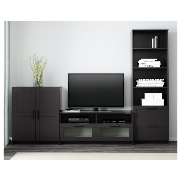 Moderner TV-Ständer mit Flachbildschirm, Schubladen, Regalen, schwarzen Schränken, Bücherregal mit Dekor und Büchern.