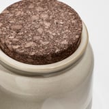 Nahaufnahme eines Steinzeugglases mit Korkdeckel, das seine hochwertige, strukturierte Oberfläche und seinen sicheren Sitz zur Geltung bringt.