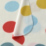 Mehrfarbige Polka-Dot-Decke mit roten, gelben und blauen Punkten auf weiß.
