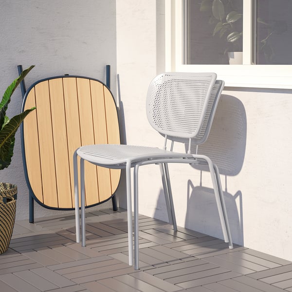 Moderne DUVSKÄR-Stühle, einer mit Holzrückenlehne, auf der Terrasse.