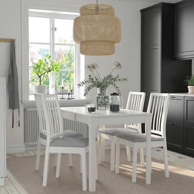 Moderner Essbereich mit ausziehbarem EKEDALEN-Tisch, Korblicht, grauen Stühlen, schwarzen Schränken, Blumendekor und natürlichem Licht.