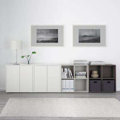 Weiße EKET-Aufbewahrung mit einer Mischung aus geschlossenen und offenen Regalen, Schwarz-Weiß-Fotos, Lampe, Büchern, Dekor, weichem Teppich.