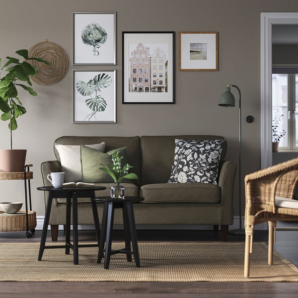 Olivensofa, botanische Kunst, Korbstuhl, Beistelltisch mit Becher und Pflanze.