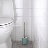 Minimalistisches Badezimmer mit weißer Toilette, blauem Bürstenhalter und grauer Bürste.