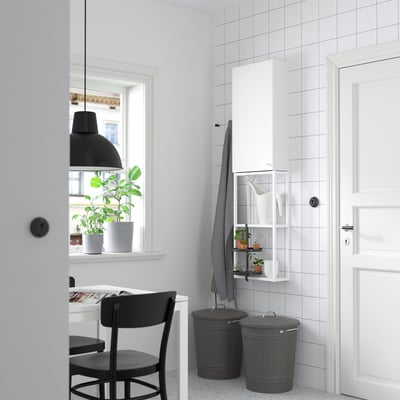 Moderner Waschraum mit weißem ENHET-Schrank, schwarzen Akzenten, Zimmerpflanze und hängenden Handtüchern.