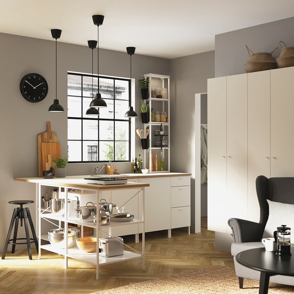 Moderne Küche mit weißen ENHET-Schränken und Holztheke, Hängelampen, einer Uhr und einem Sitzbereich.