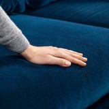 Hand auf blauem Samt FAMMARP Sofa, weiches, luxuriöses Gefühl.