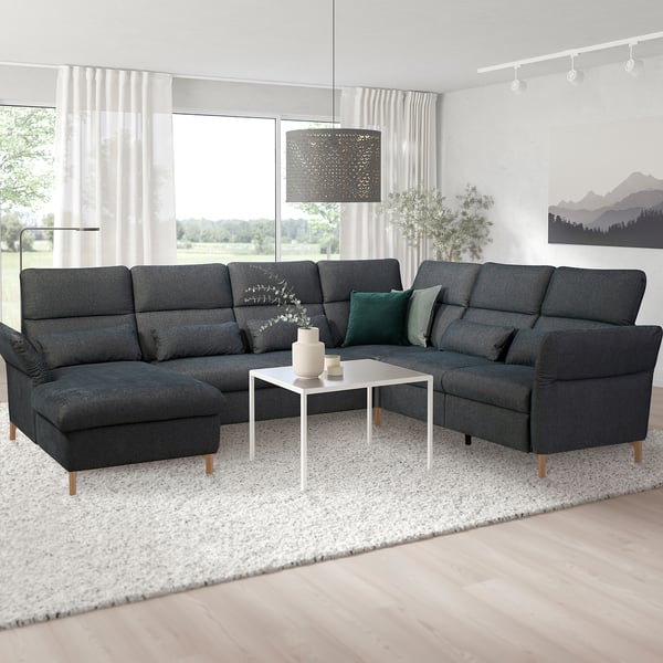Modernes Wohnzimmer mit großem dunkelgrauem L-förmigem FAMMARP-Sofa, weißem Couchtisch und großen Fenstern. Konfitüre