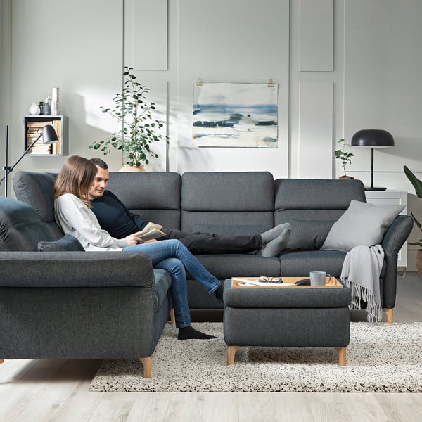 Zwei Personen entspannen sich auf dem FAMMARP-Sofa im modernen Wohnzimmer.