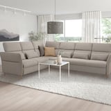 Modernes Wohnzimmer: graue FAMMARP-Sektion, weißer Couchtisch, große Fenster, minimalistische Einrichtung.