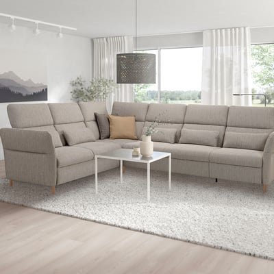 U-förmiges graues Sofa mit verstellbaren Teilen im hellen Wohnzimmer, weißer Couchtisch, Pendelleuchte, großes Fenster.