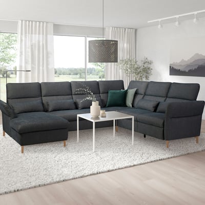 Modernes graues Sektionssofa im Wohnzimmer mit Couchtisch, Teppich, Vorhängen und großem Fenster.
