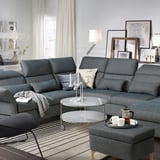 Modernes Wohnzimmer mit grauem FAMMARP-Sofa, rundem Glastisch und eleganter Einrichtung.