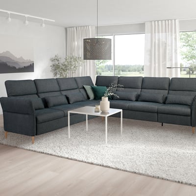 Modernes Wohnzimmer mit grauem U-förmigem FAMMARP-Sofa, Couchtisch, großen Fenstern und verstellbaren Kopfstützen.