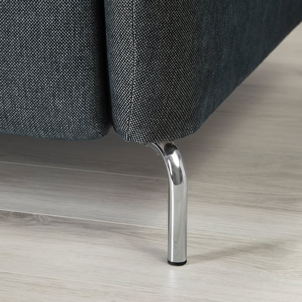 Nahaufnahme eines modernen Sofabeins mit elegantem Chrom-Finish, das an einem gepolsterten Gestell auf einem stilvollen, polierten Holzboden befestigt ist.