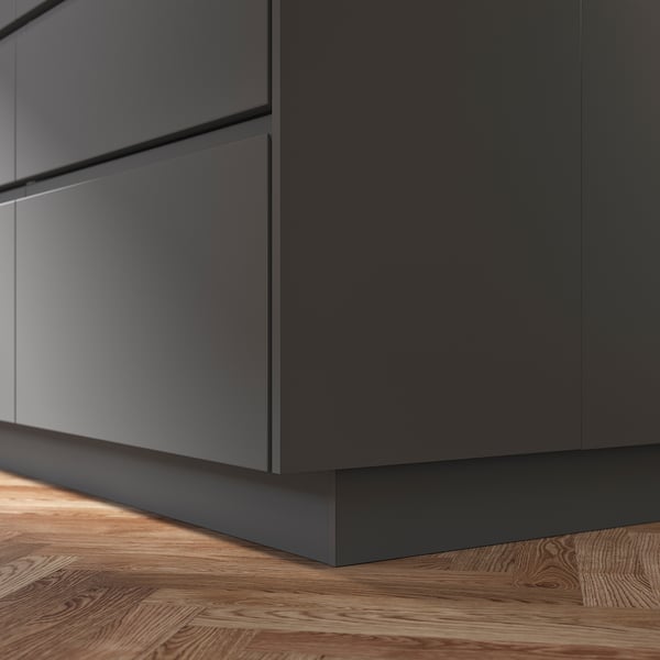 Grauer FÖRBÄTTRA Küchenschranksockel auf Holzboden.